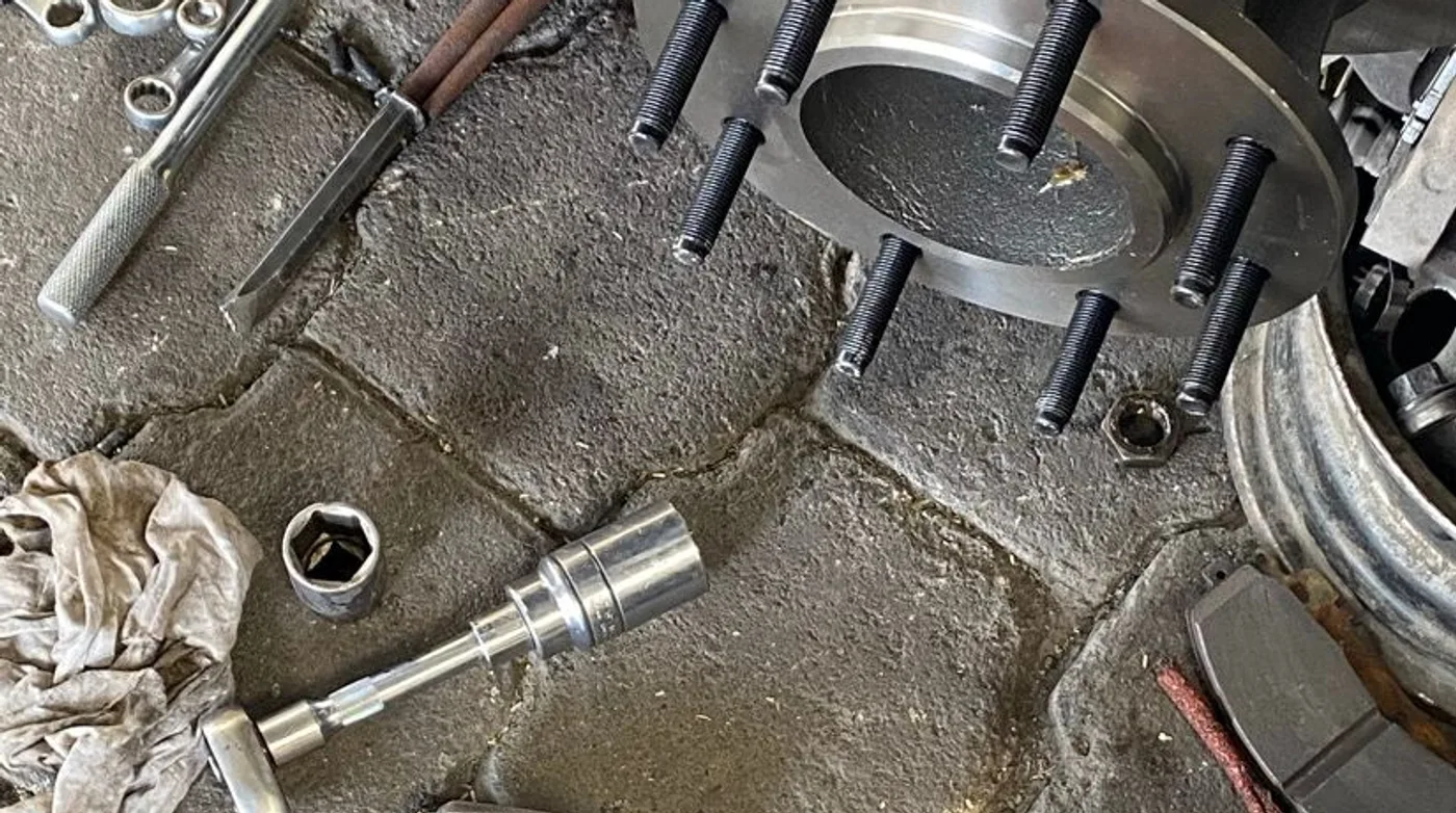Maza, birlos, balatas y disco desmontados durante una reparación